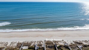 Een strand met een promenade die naar het strand leidt.