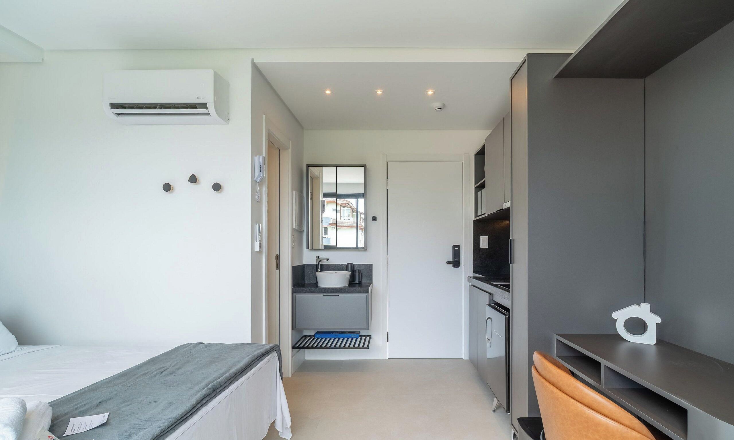 Een moderne slaapkamer met een bed, nachtkastje en een inbouwkast.