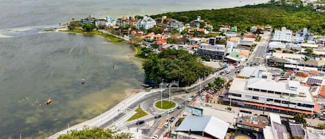 An aerial view of a coastal town with a marina, roads, and buildings.