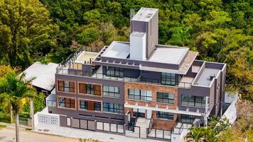 Una casa moderna de varios pisos con techo plano, ventanas grandes y un balcón.