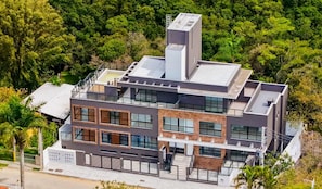 A multi-story modern house with a flat roof, large windows, and a balcony. - Modern Studios 150m From Lagoa da Conceicao - Lsts II (Florianópolis)