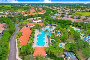 A residential area with a central swimming pool, surrounded by houses and greenery. - Luxury Accessible Home - Resort + Lazy River (Davenport)