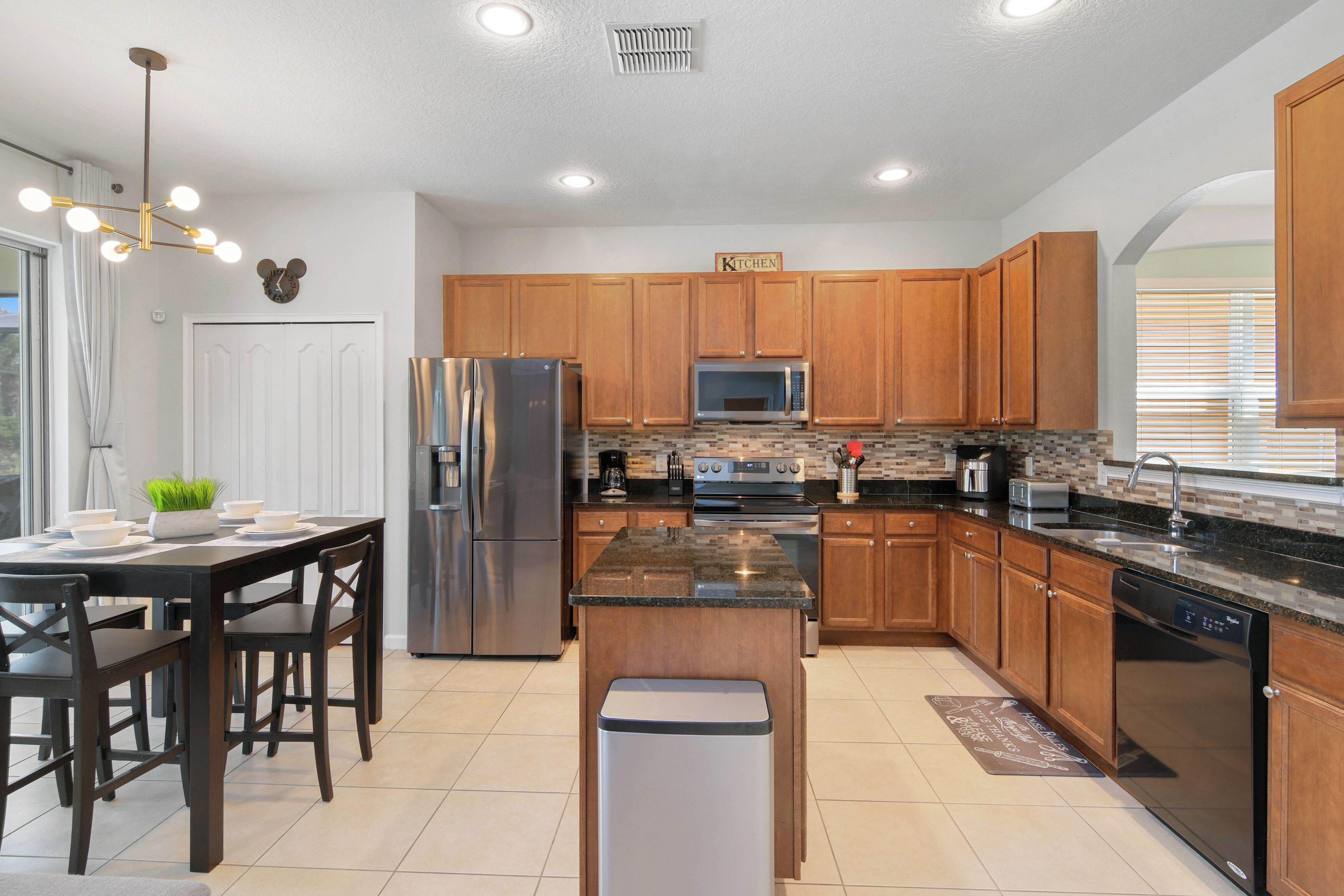 A modern kitchen with wooden cabinets, stainless steel appliances, and a granite countertop.