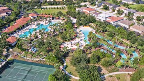 An aerial view of a resort with multiple swimming pools, a tennis court, and residential buildings. - Family Paradise - Theatre + Resort + Pet Friendly (Davenport)