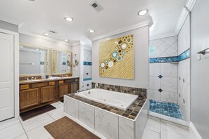 A modern bathroom with a large bathtub, double sinks, and a shower area. - The Farm House - Great Location + Pet Friendly! (Windermere)