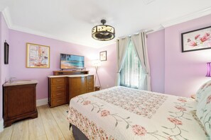 A bedroom with a bed, a dresser, a vanity, a painting, and a ceiling fan. - The Farm House - Great Location + Pet Friendly! (Windermere)