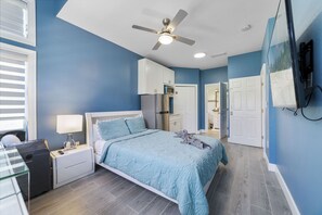 A bedroom with a bed, nightstand, lamp, and a ceiling fan. - Emerald Garden - Resort - 15 Min to Disney - Pets (Kissimmee)