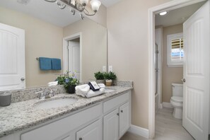 A bathroom with a double sink, a mirror, a towel rack, and a potted plant. - The Charming Chateau - Luxe - Resort - Location (Davenport)