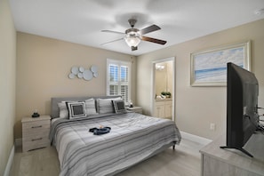 A bedroom with a bed, a ceiling fan, a TV, a dresser, a nightstand, and a window. - The Charming Chateau - Luxe - Resort - Location (Davenport)