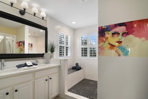 A bathroom with a large mirror, two sinks, a bathtub, and a window with blinds. - The Charming Chateau - Luxe - Resort - Location (Davenport)