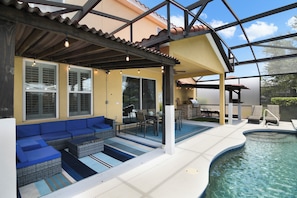 A covered outdoor area with a pool, seating, and a barbecue setup. - The Charming Chateau - Luxe - Resort - Location (Davenport)