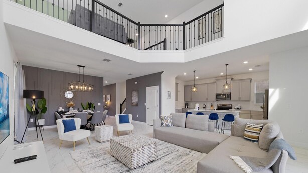 A spacious living area with a high ceiling, a dining area, and a kitchen. - Champions Oasis - Resort&arcade -walk to Clubhouse (Davenport)