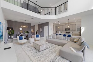 A spacious living area with a high ceiling, a dining area, and a kitchen. - Champions Oasis - Resort&arcade -walk to Clubhouse (Davenport)
