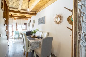Comedor con mesa, sillas y techo de vigas de madera.
