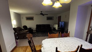 A dining area with a table covered in a patterned tablecloth, surrounded by wooden chairs. -  4-bedroom house in Dublin close to ,zoo shopping,restaurant,airport ,5 star (Dublin)
