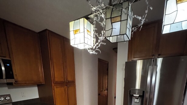 A kitchen with wooden cabinets, a granite countertop, stainless steel appliances, and a decorative stained glass light fixture. -  4-bedroom house in Dublin close to ,zoo shopping,restaurant,airport ,5 star (Dublin)