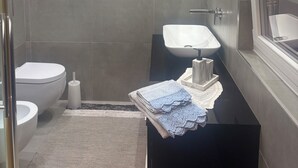 Une salle de bain moderne équipée de toilettes, d’un bidet et d’un lavabo.