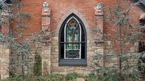 A Gothic-style window with stained glass, flanked by stone walls and two stone gargoyles. - ★ Indoor Heated Pool ★ Sports Court ★ Putting Green & Mini Golf ★ Fun for all!! (Eudora)