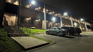 Een meerlaags gebouw met een parkeerplaats ervoor.