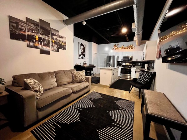 Un salon moderne avec un canapé, une table basse et un tapis à motifs.