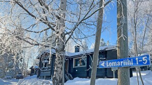 A snow-covered house with a blue sign indicating the address. - Lomariihi 4 (Muurame)