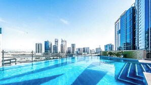 Piscina infinita no terraço com vista para o horizonte da cidade.