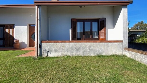 A modern single-story house with a flat roof, a front porch, and a small front yard. - At Licia's house (Cuggiono)