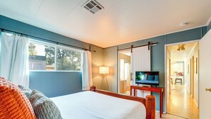 Een slaapkamer met een groot bed, een televisie en uitzicht.