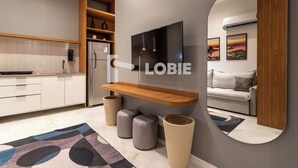 Una cocina moderna con un refrigerador empotrado, un estante de madera y un espejo grande.