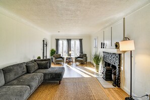 A modern living room with a sectional sofa, a fireplace, and a dining area. - Home w/ Spacious Yard, 3 Mi to Dtwn Des Moines! (Des Moines)
