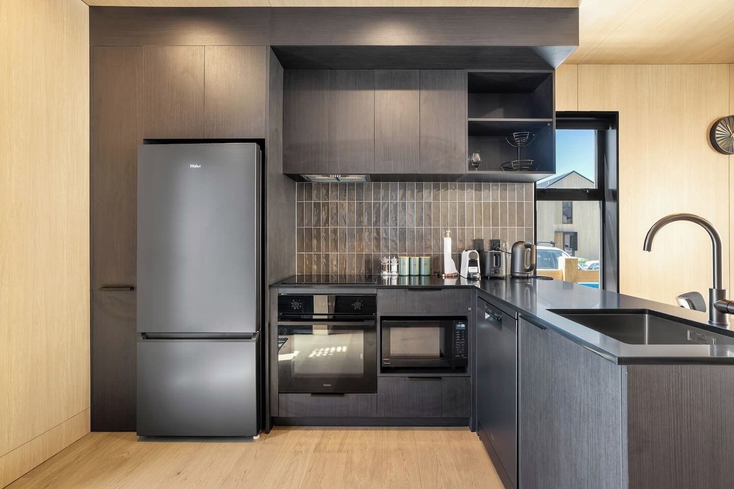 Eine moderne Küche mit integriertem Kühlschrank, Backofen, Mikrowelle und Spüle.