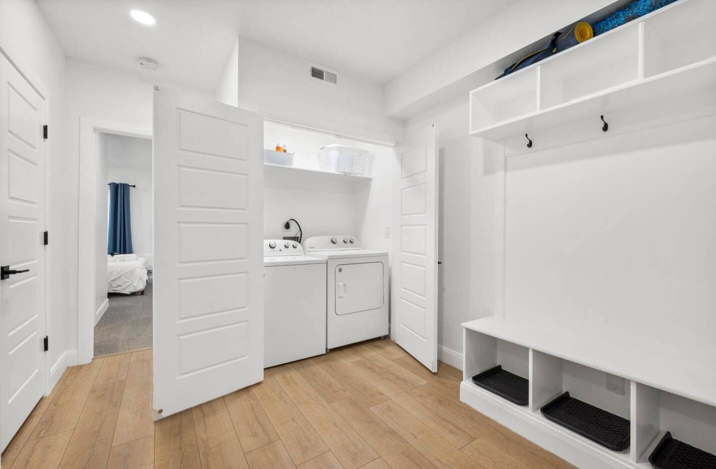 A compact laundry room with a washing machine, dryer, and a small sink.