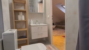 A compact bathroom with a white sink, mirror, and storage shelves. - KindStay Suite 2 bedroom Apartment w/ Free Parking near Prague Airport (Praha-Zapad)