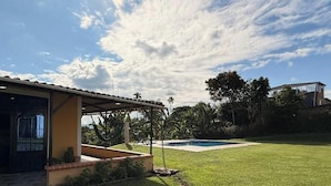 A house with a covered patio, a swimming pool, and a well-maintained lawn. - PARCEROS GROUP - 4-BEDROOM VACATION FARM, MORELIA, PEREIRA, COLOMBIA (La Estrella)