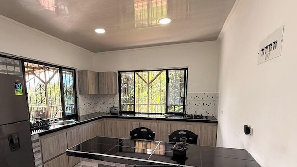 A modern kitchen with a refrigerator, double sink, and large windows. - PARCEROS GROUP - 4-BEDROOM VACATION FARM, MORELIA, PEREIRA, COLOMBIA (La Estrella)