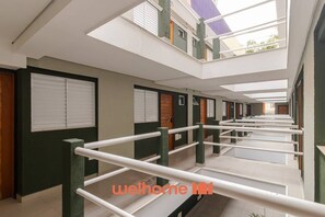 Ein Hotelgang mit mehreren Zimmern, einem zentralen Gehweg und Dachfenstern.