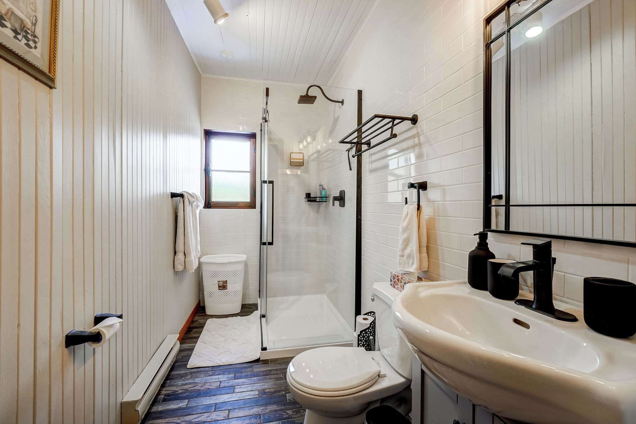 Een moderne badkamer met douche, toilet en wastafel.