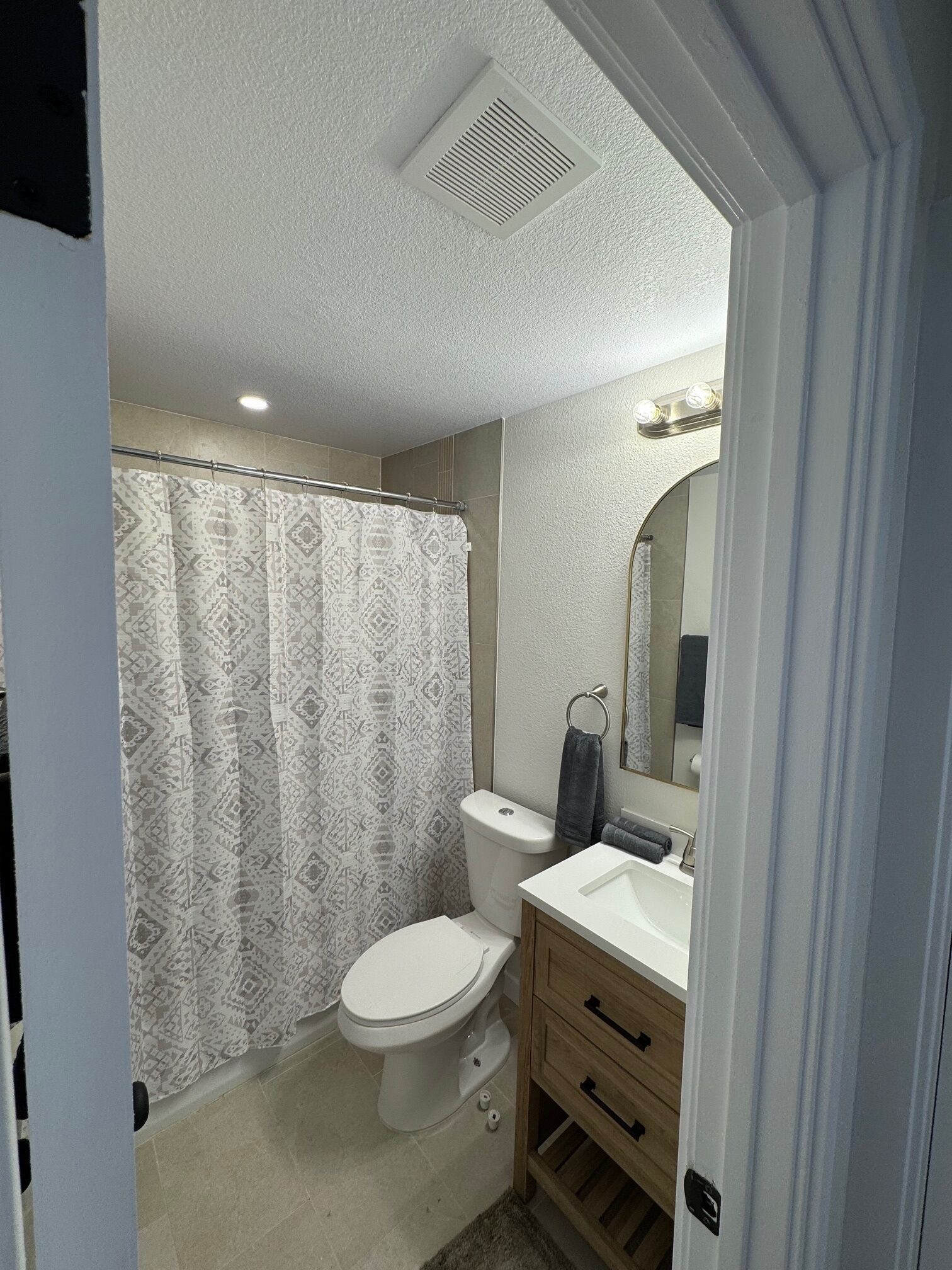 Une salle de bain équipée de toilettes, d’un lavabo et d’un rideau de douche.