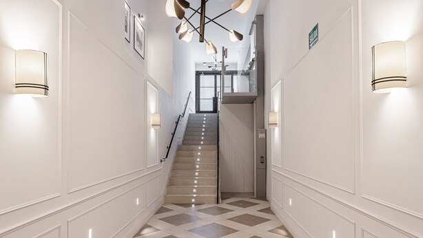 A hotel hallway with a checkered floor, white walls, and wall-mounted lighting. - Waou Urban Home Salamanca V (Madrid)