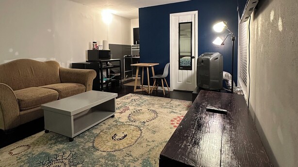 Una sala de estar con un sofá, una mesa de centro y un televisor sobre un mueble.