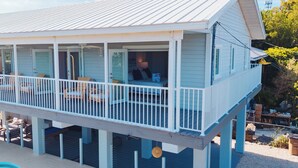 A two-story house with a balcony, a pool, and a garage.