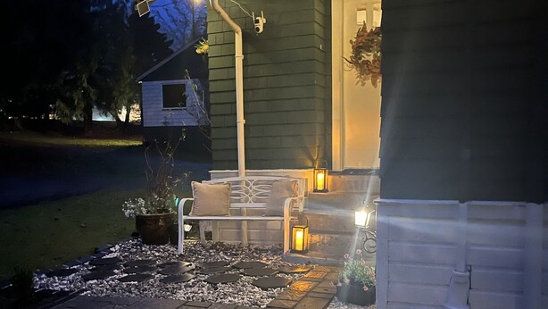 Eine Terrasse mit Sitzgelegenheiten, einer Laterne und Lichterketten.