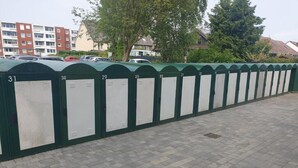 A row of numbered lockers, likely for storage or personal items, lined up along a paved walkway.