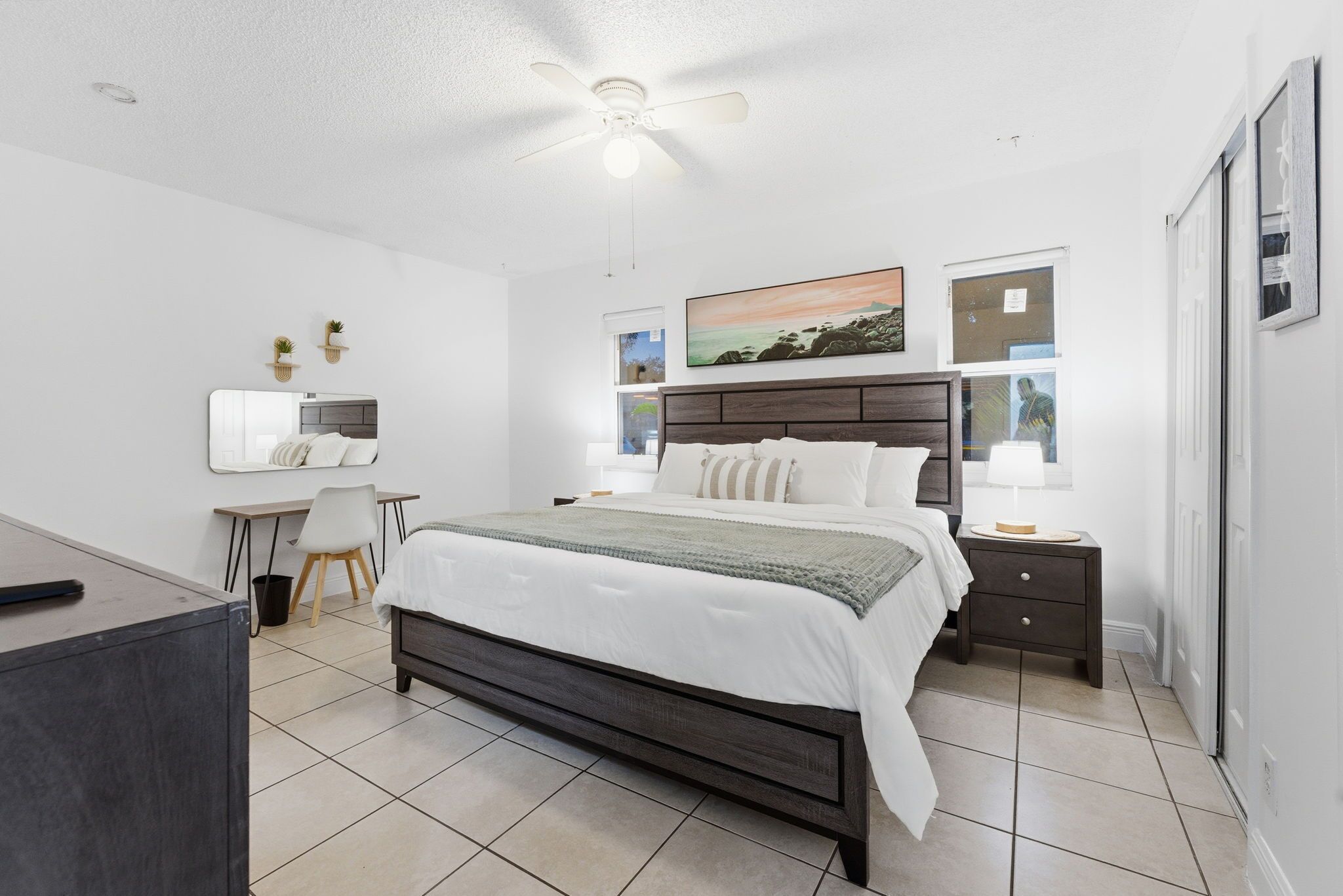 Une chambre à coucher moderne avec un grand lit, un bureau et une chaise.