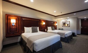 A hotel room with two beds, wooden headboards, and bedside lamps. - Executive Double Queen Room with Modern Amenities & Breakfast (Hillsdale)