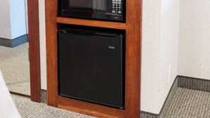 Une petite cuisine équipée d’un four à micro-ondes, d’une machine à café et d’un réfrigérateur.