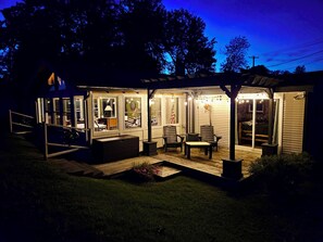 A house with a covered porch, a dining area, and a visible bedroom.