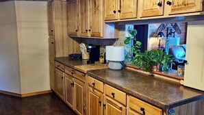A kitchen with wooden cabinets, a countertop, and a ceiling light fixture. - 130 Feet of Lakefront with Unforgettable Views and Access (Plattsburgh)