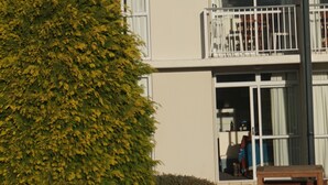 Ein modernes, zweistöckiges Haus mit Balkon und großen Fenstern.