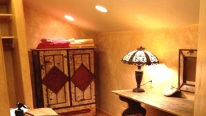 Una habitación acogedora con una mesa de madera, un cuenco, una lámpara y un banco.